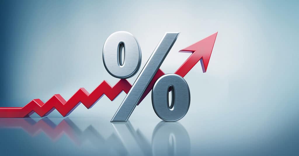 Percentage sign standing on reflective surface with red arrow moving up on defocused  background. Horizontal composition with copy space.
